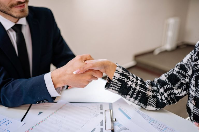 Close-up of a business handshake over documents, symbolising a trusted partnership
