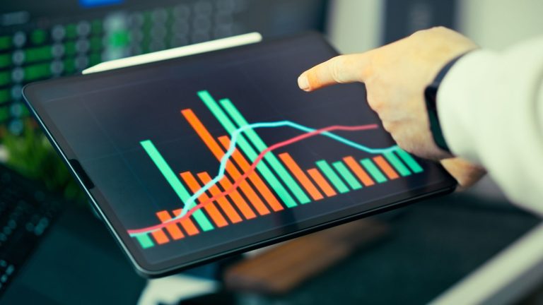 Person analysing business data with colourful graphs on a tablet screen